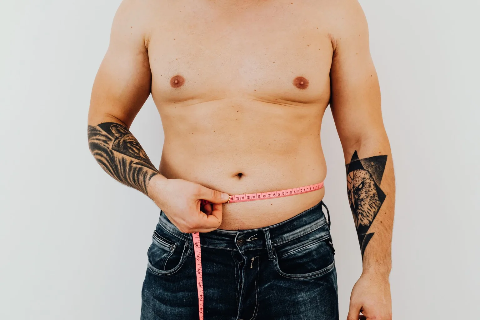 Man measuring his waist with a tape measure